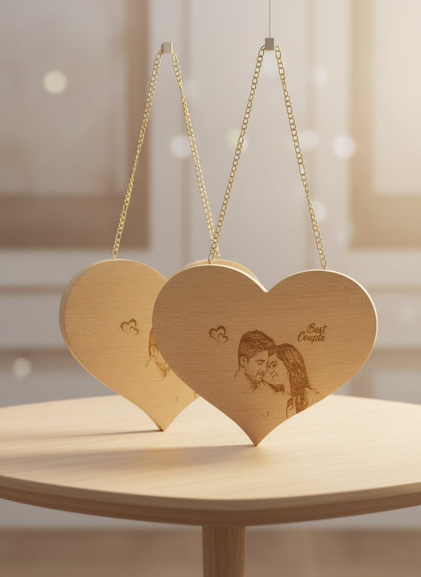 Wooden heart-shaped plaque with engraved couple's portrait and 'Best Couple' text, hanging on a glass shelf.
